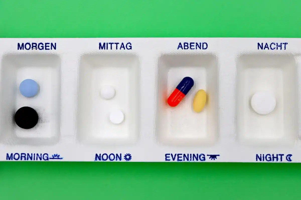 Pilulier organisé avec médicaments et rappels pour gestion des traitements