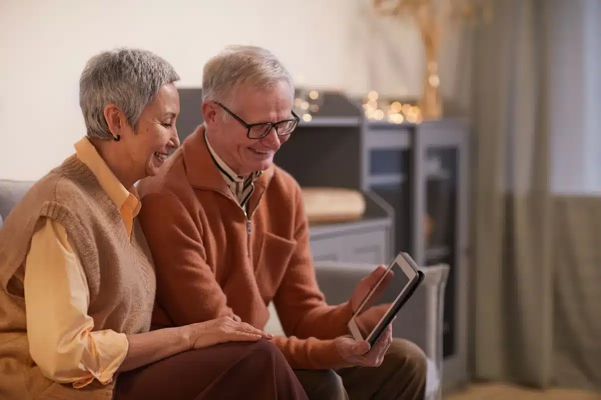 Personne âgée utilisant une tablette pour un appel vidéo avec sa famille