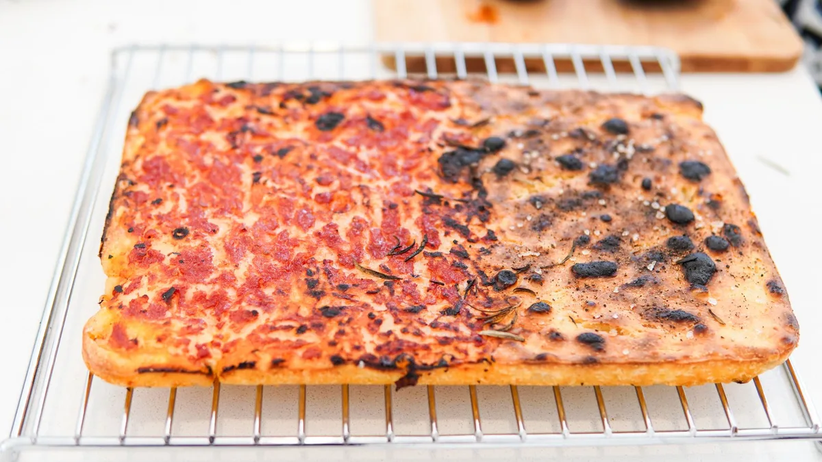 Focaccia en cours de cuisson au four avec une croûte dorée uniforme