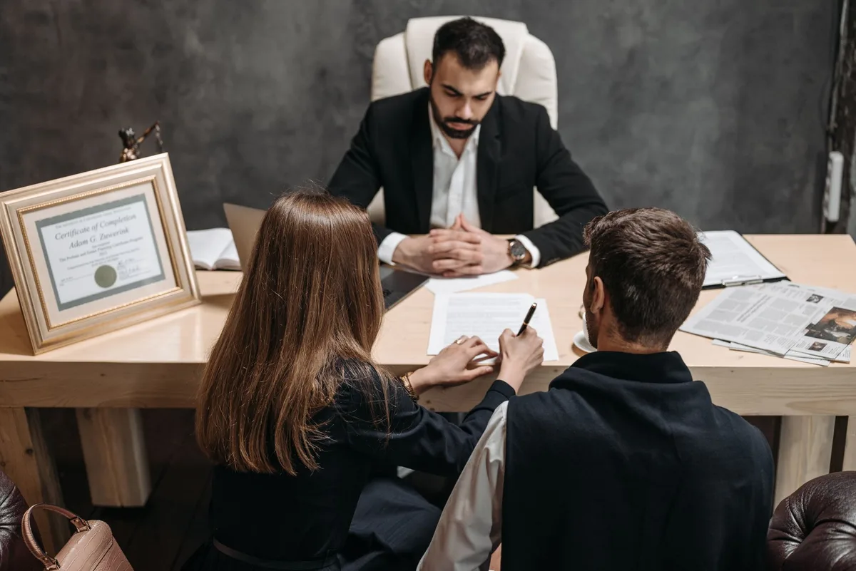 Avocat et client en consultation examinant des documents et dossiers juridiques