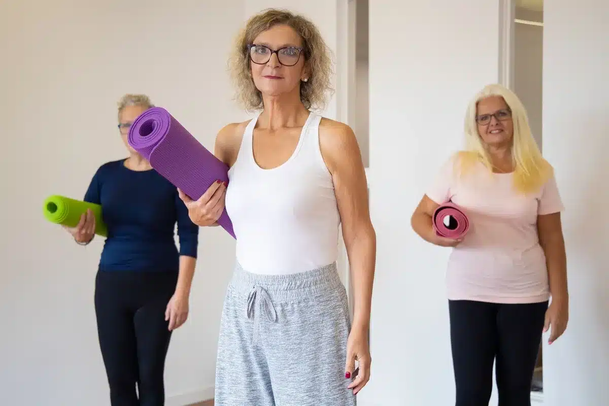 Seniors effectuant une séance de gymnastique douce en groupe dans une salle lumineuse