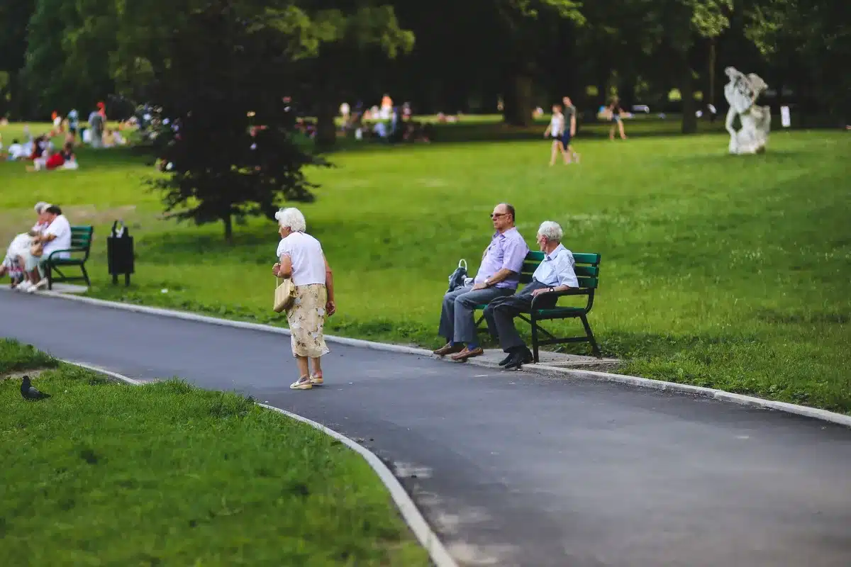 Jardin extérieur avec cheminements plats, bancs de repos et zones ombragées pour personnes âgées