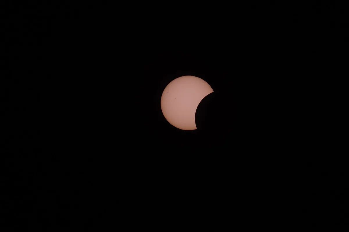 Ombre d'une éclipse solaire sur un ciel bleu, moment d'obscurité cosmique