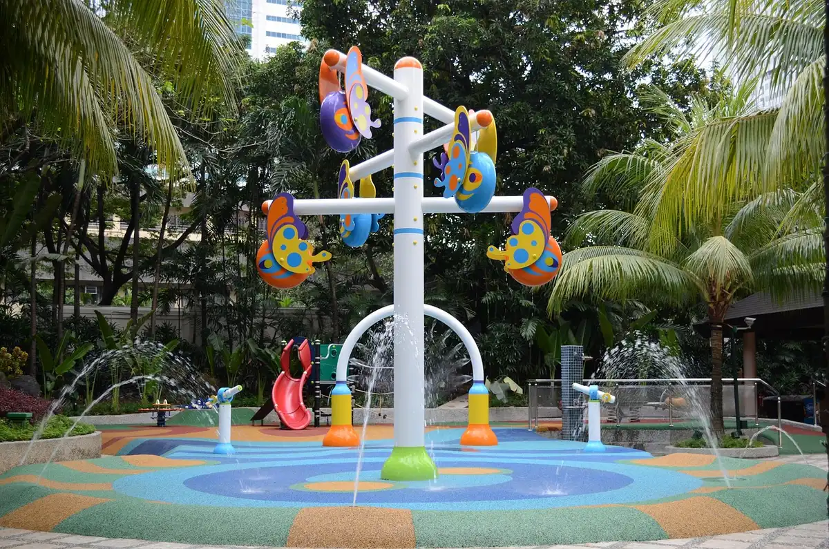 Enfants jouant ensemble sur une aire de jeux accessible, silhouettes non identifiables