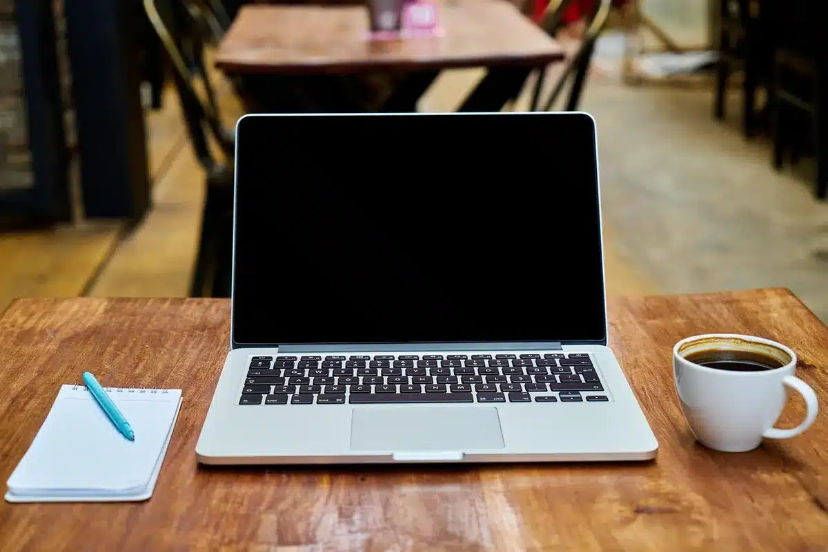 Carnet ouvert avec une checklist et deux tasses sur une table