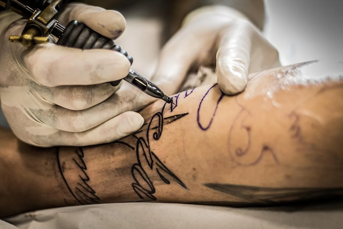 Machine de tatouage fixée avec du ruban adhésif renforcé sur une main