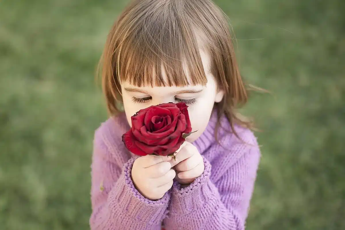 Personne inspirant un parfum près d'une fenêtre en pleine journée