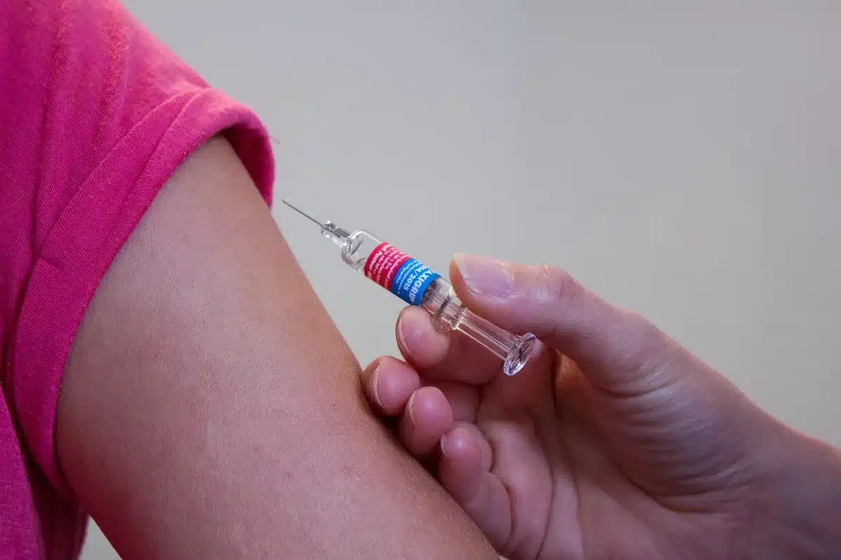 Vétérinaire préparant un vaccin intranasal et une seringue posée sur une table