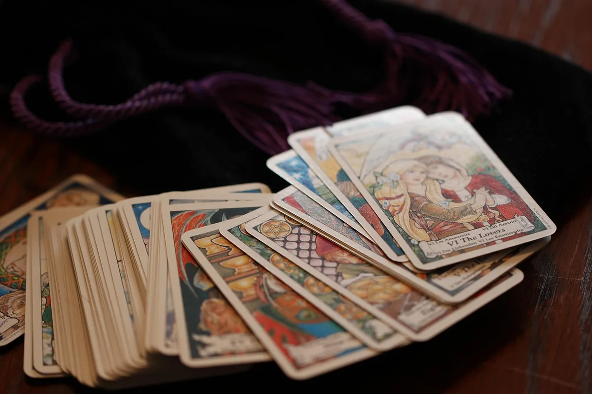 Personne feuilletant des jeux de tarot en boutique pour choisir