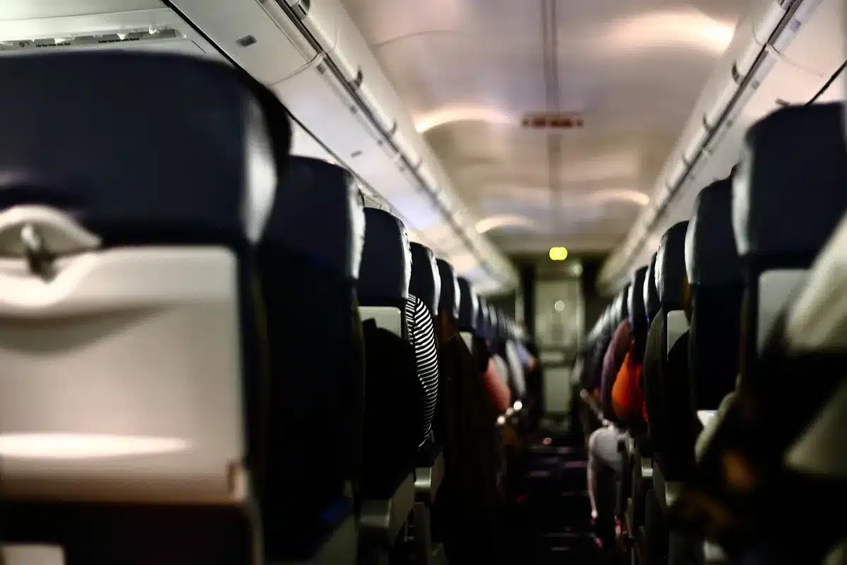 Mains de passagers attachant une personne à son siège dans une cabine