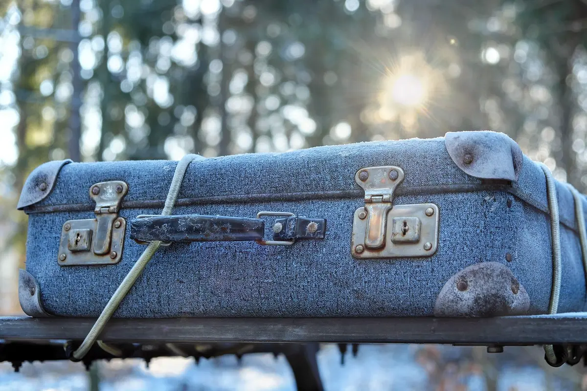 Parking en journée avec une valise ouverte posée au sol