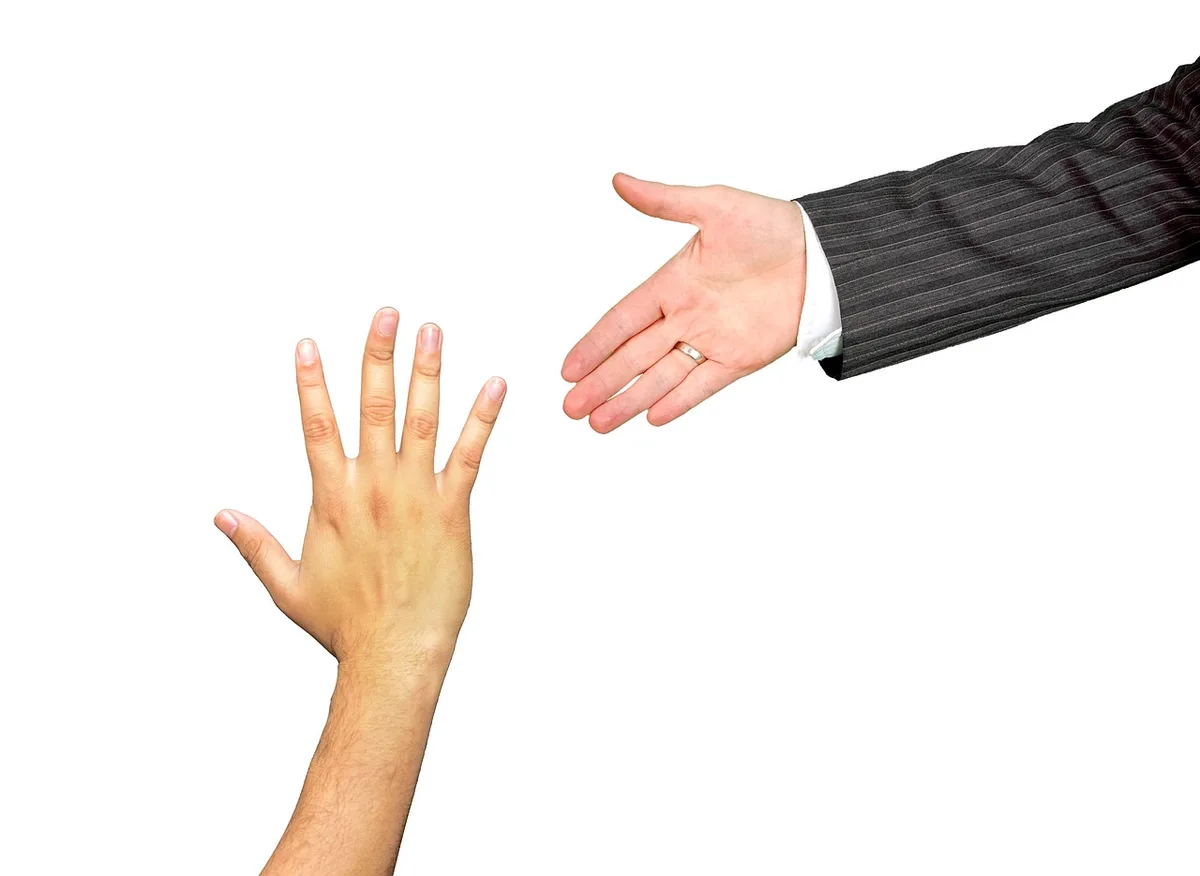 Mains se tendant pour aider, geste de soutien concret
