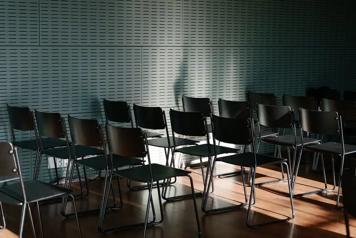 Chaise vide près d'une fenêtre en plein jour, évoquant la perte et la désorientation