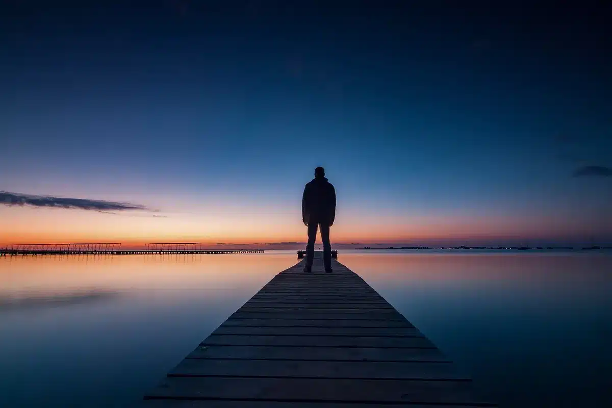 Personne pensive assise sur un banc, montrant la rumination et l'idéalisation
