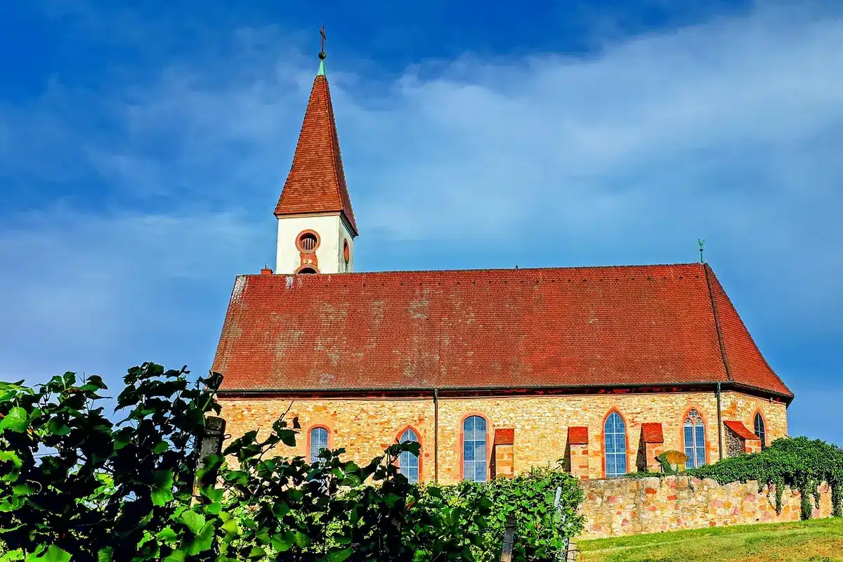 Porteurs en procession devant une église en plein jour