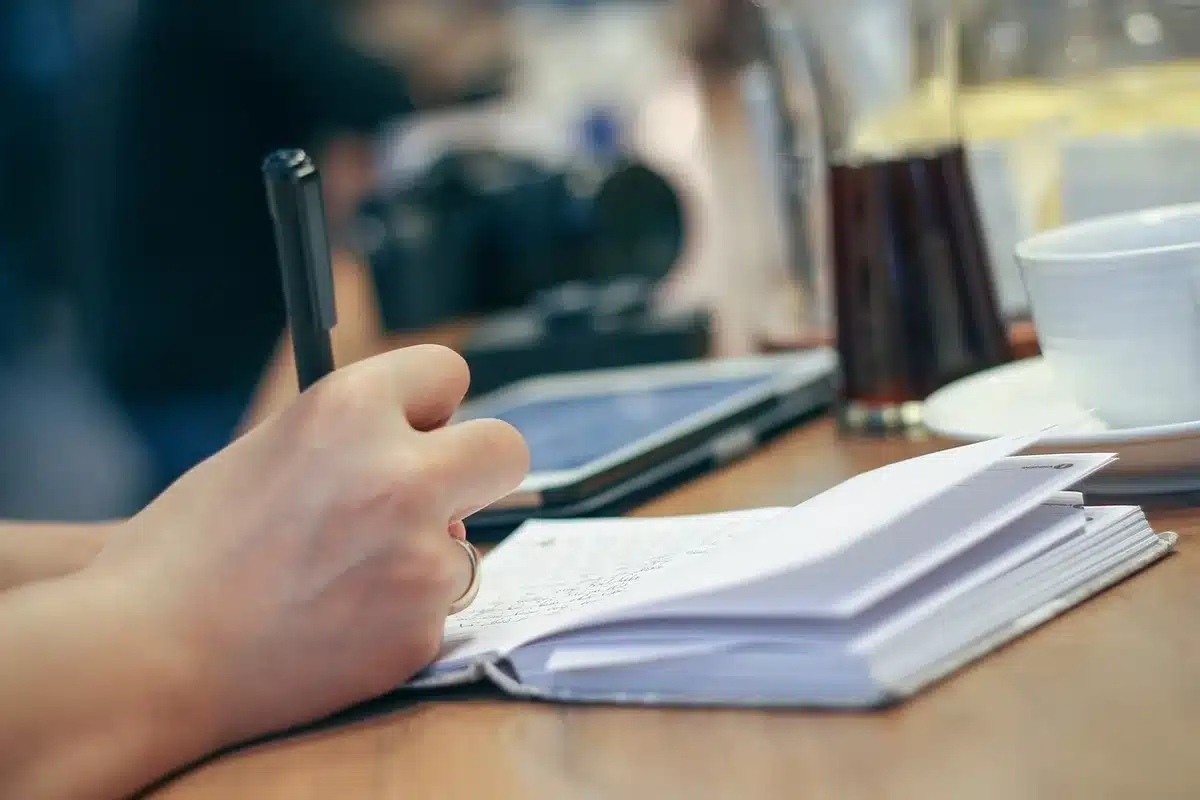 Deux personnes discutant dans une cuisine avec des notes et un carnet