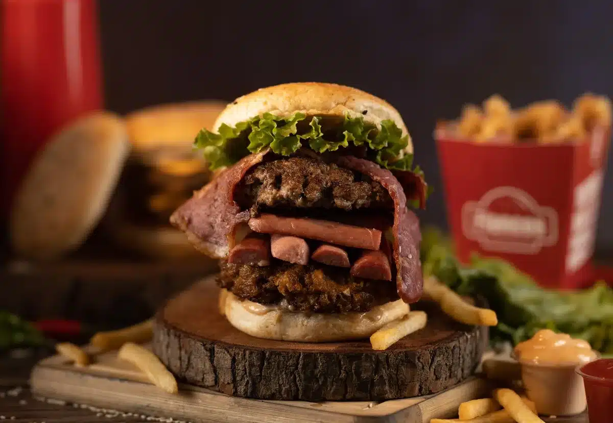 Burger empilé montrant plusieurs steaks et tranches de fromage